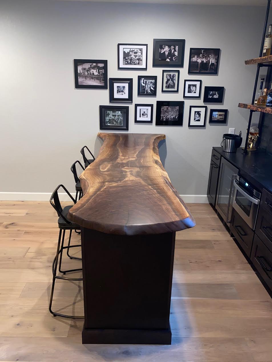 Claro Walnut live edge bar to with radius end and family photo display on the wall.