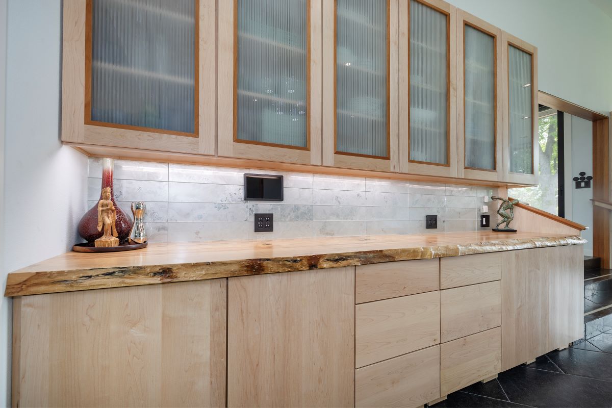 Live edge modern bar top with light colored wood slab.