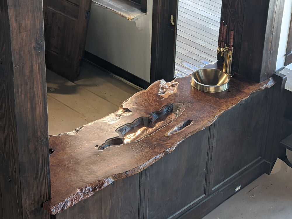 Luxury Redwood Burl bar top with copper sink and copper inlay. Custom made to fit the space.