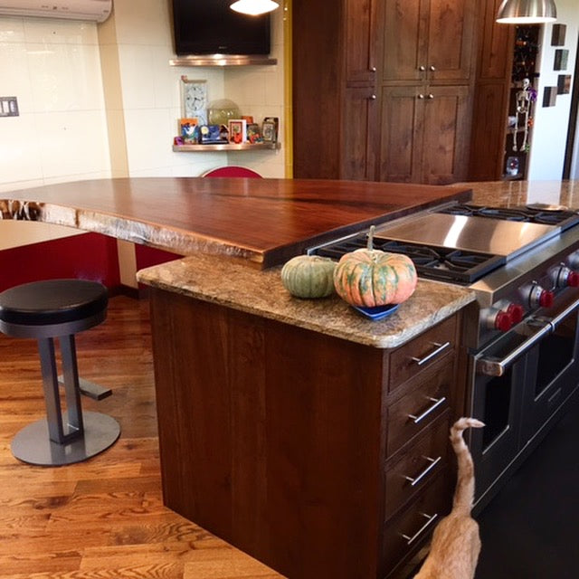 Wide single walnut slab kitchen island extension for family dining.