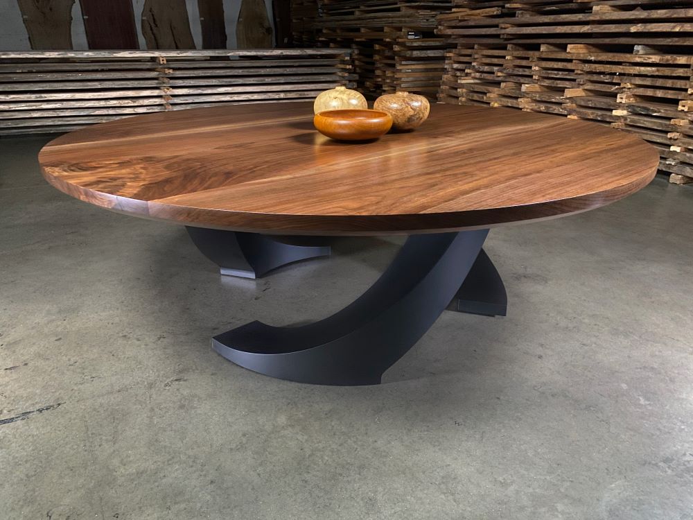 Round solid wood dining table with a modern custom made black base.