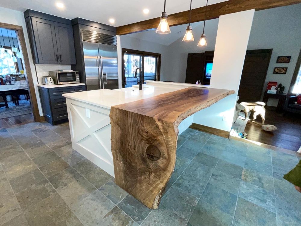 Modern kitchen with a Walnut kitchen island extension with waterfall leg and white marble countertop. 