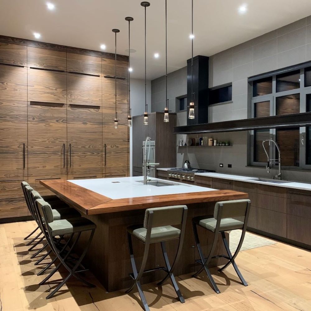 Minimalist luxury kitchen design featuring a wrap around walnut kitchen island extension and seating for six. 